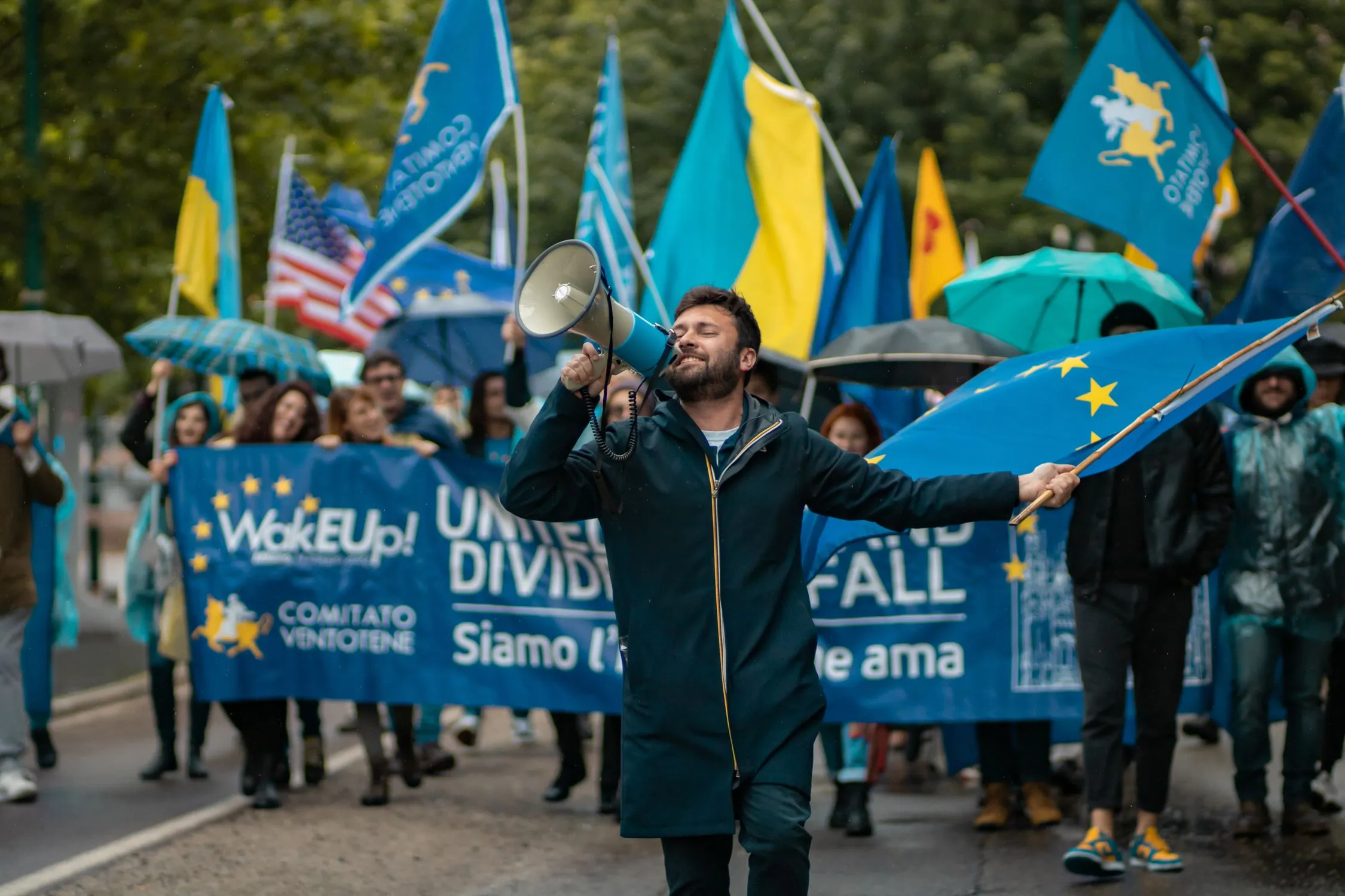 Manifestanti con bandiere ucraine e cartelli in una piazza di Milano