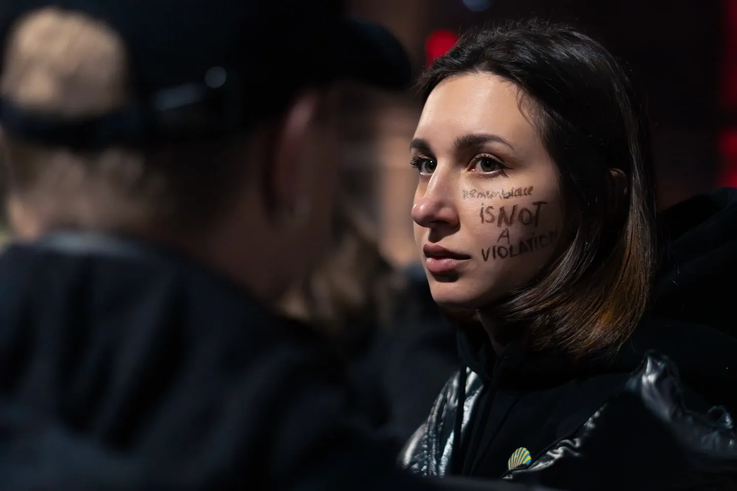 Una partecipante al flash mob con la scritta “remembrance is not a violation” sul viso
